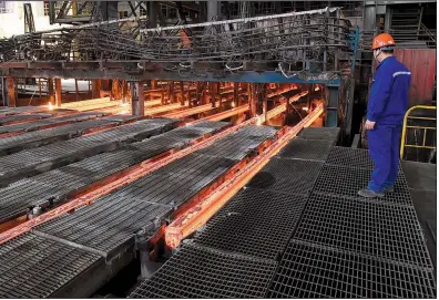  ?? AP file photo ?? A steelworke­r at Xiwang Special Steel in Zouping County in eastern China’s Shandong province oversees production last week. Chinese steel mills account for half the world’s steel production.