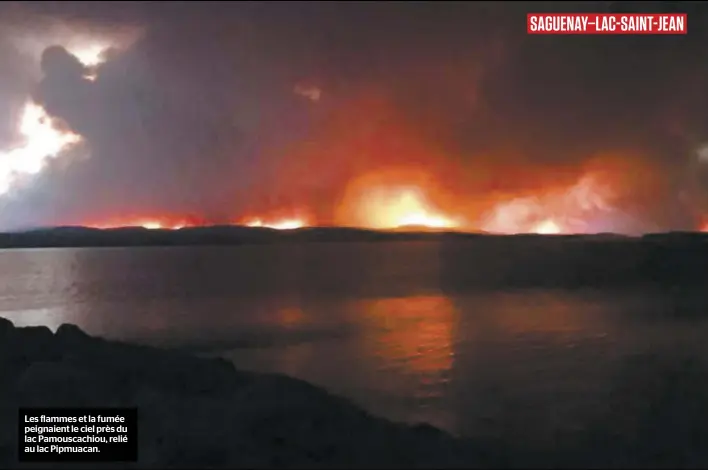  ??  ?? Les flammes et la fumée peignaient le ciel près du lac Pamouscach­iou, relié au lac Pipmuacan. SAGUENAY–LAC-SAINT-JEAN