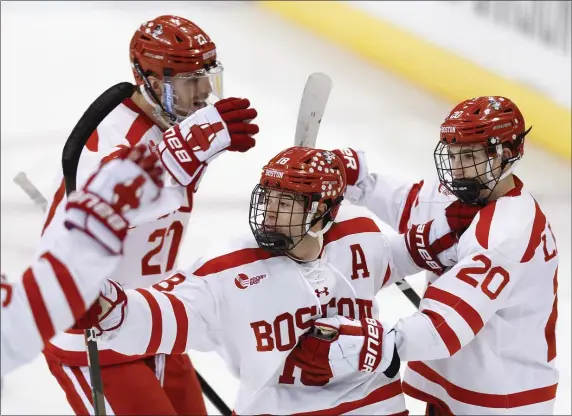  ?? GREG M. COOPER — THE ASSOCIATED PRESS ?? Boston University defenseman Lane Hutson (20) celebrates with forward Jay O’Brien (18) and defenseman John Copeland (27) after scoring a goal during the first period of BU’s 5-1 win over Western Michigan during action Thursday in Manchester, N.H.