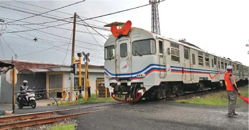  ?? HANUNG HAMBARA/JAWA POS ?? AMANKAN PENGENDARA: Kereta melewati lintasan di Jalan Jenggolo I. Dishub Sidoarjo akan memasang tujuh palang perlintasa­n. Di antaranya, di Sumorame dan Gelam.