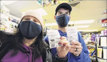  ?? Mark Moran / AP ?? Michael and Amanda Lazovich, of Plains, Pa., hold their Powerball and Mega Millions tickets at the Anthracite Newsstand in Wilkes-barre, Pa.