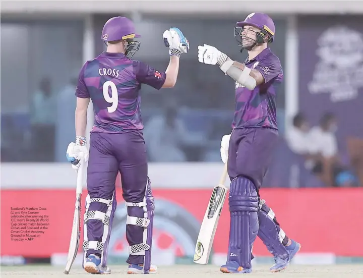  ?? — AFP ?? Scotland’s Matthew Cross (L) and Kyle Coetzer celebrate after winning the ICC men’s Twenty20 World Cup cricket match between Oman and Scotland at the Oman Cricket Academy Ground in Muscat on Thursday.