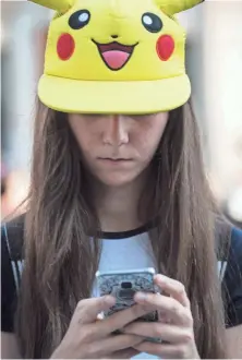  ?? PEDRO ARMESTRE, AFP/GETTY IMAGES ?? Donning a Pikachu hat, a girl looks for Pokémon in Madrid on July 28, 2016. The game has raked in $1.2 billion in revenue.