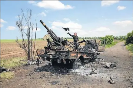  ?? JOHN MOORE / GETTY IMAGES ?? Un hombre se lleva partes de un vehículo militar ucraniano quemado en Dimitrivka