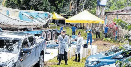  ?? EL PAÍS ?? Acto. Oficiales de policía inspeccion­an objetos retirados del bote, donde especialis­tas llaman pateras fantasma