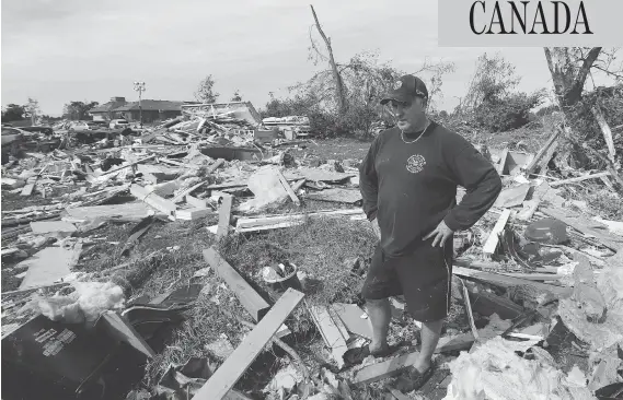  ?? JEAN LEVAC / POSTMEDIA NEWS ?? Brian Lowden takes a moment to collect himself while surveying the wreckage of his home on Sunday in Dunrobin, Ont., just outside Ottawa.