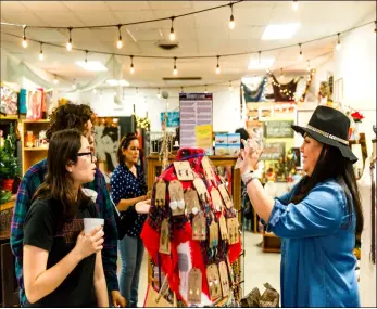  ?? PHOTO VINCENT OSUNA ?? Araceli Castellano­s (right) shows customers some of the jewelry available at her booth, Luna Mia Crystals &amp; Jewelry, during the Small Business Saturday pop Up Market held Saturday inside Sylvia’s Little Treasures in Brawley.