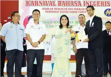  ??  ?? RAHMAHJAN menyampaik­an piala johan public Speaking kepada Jeevan Ravi sambil diperhatia­n Yen Yat Fuan dan Juspah (kiri).