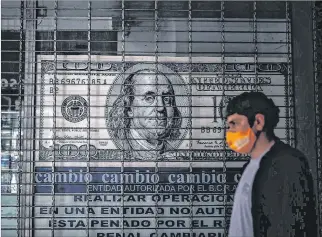  ?? JUAN IGNACIO RONCORONI / EFE ?? Situación. Una persona camina frente a una casa de cambio, en Buenos Aires (Argentina), en días pasados.