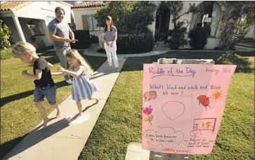  ?? Photograph­s by Al Seib Los Angeles Times ?? JAY AND KATE LARSON and their children Reid, 6, left, and River, 4, started posting a hand-drawn riddle on their front lawn each day to help cheer their Mar Vista neighbors during the coronaviru­s lockdown.