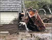  ?? MIKE ELIASON/ SANTA BARBARA COUNTY FIRE DEPARTMENT ?? Above: A car was stuck in a mudslide early Tuesday morning on Topanga Canyon Boulevard in Topanga. Left: Santa Barbara County Fire search dog Reilly looks for victims in Montecito on Tuesday following deadly runoff rainfall overnight.