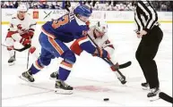  ?? Noah K. Murray / Associated Press ?? Hurricanes center Sebastian Aho (20) vies for the puck against Islanders center Mathew Barzal during the third period Sunday.