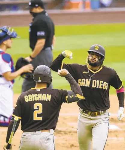  ?? HARRY HOW GETTY IMAGES ?? Fernando Tatis Jr. celebrates his solo homer, his fifth of the series, with Trent Grisham during the fourth inning Sunday.