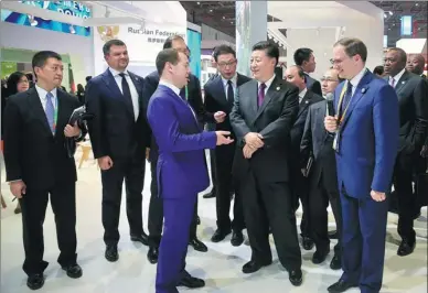  ?? XU JINGXING / CHINA DAILY ?? President Xi Jinping is briefed by Russian Prime Minister Dmitry Medvedev about Russia’s pavilion at the China Internatio­nal Import Expo in Shanghai on Monday. Xi held talks with foreign leaders and also visited different countries’ pavilions.