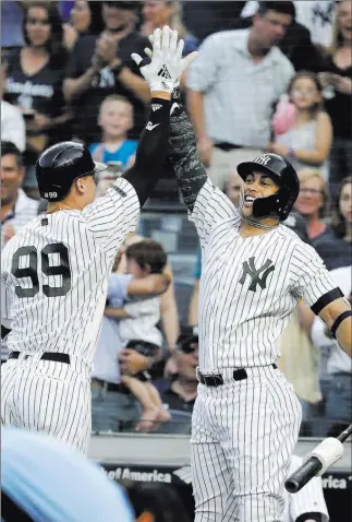  ?? Julio Cortez ?? The Associated Press Yankees sluggers Giancarlo Stanton, right, and Aaron Judge celebrate Judge’s home run Saturday in New York. The Yankees might end up regretting having to pay Stanton until he’s 38.