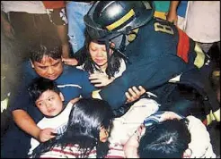  ??  ?? In a photo posted on Facebook by Fire Officer 2 Lords Hernandez, a fireman tends to 10-year-old Horacio Castillo III and his parents after their rescue from a fire that engulfed their home in 2005.