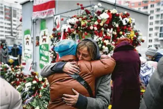  ?? Associated Press ?? Two women embrace as people gather to honor Raman Bandarenka, an opposition supporter who died Thursday at a Minsk hospital after reportedly being beaten by security forces.