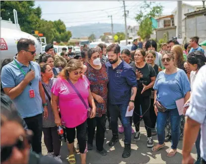  ?? MARCELO SEGURA / CHILEAN PRESIDENCY / AFP ?? Chile’s President Gabriel Boric (center) on Feb 4 visits residents of Quilpue, a hillside community in Vina del Mar, which was affected by forest fires.