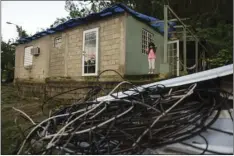  ?? PHOTO/ ?? In this December photo, six year old Melanie Oliveras González stand on the porch of her house, in front of a handful of electric cables knocked down by the winds of Hurricane Maria, in Morovis, Puerto Rico. Morovis has been without power since...