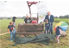  ?? FOTO: HS ?? Vier Kinder entfernten mit Maike Beckmann (Heimatvere­in) und Wolfgang Lensing (Volksbank) die Plane von der gestiftete­n Eichenbank.