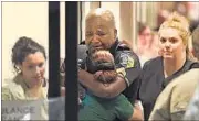  ?? AP PHOTO ?? A police officer is comforted at a hospital in Dallas after several of his colleagues were shot by snipers.