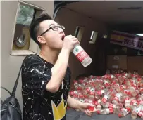  ?? AFP ?? A passerby drinking polluted water that was collected in mineral water bottles at a roving exhibition in Beijing.—