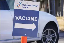  ?? DAVID ZALUBOWSKI — THE ASSOCIATED PRESS FILE ?? A sign directs motorist to a vaccinatio­n site at National Jewish Hospital on in east Denver. Merriam-Webster has declared vaccine its 2021word of the year.