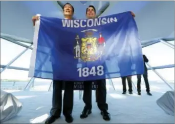  ?? MIKE DE SISTI/MILWAUKEE JOURNAL-SENTINEL VIA AP ?? Foxconn Chairman Terry Gou, left, and Gov. Scott Walker hold the Wisconsin flag to celebrate their $10 billion investment to build a display panel plant in Wisconsin, at the Milwaukee Art Museum in Milwaukee, Wis., Thursday.