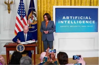  ?? EVAN VUCCI/ASSOCIATED PRESS ?? President Biden signed an executive order on artificial intelligen­ce at the White House Monday as Vice President Kamala Harris looked on.