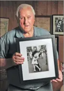  ?? PATRICK RAYCRAFT / GETTY IMAGES ?? George Mendonsa holds the iconic photo at his home in Rhode Island in 2012.