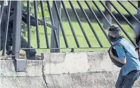  ?? EFE ?? Secuencia. Un guardia saca su arma a través de la reja de la base.