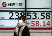  ?? EUGENE HOSHIKO — THE ASSOCIATED PRESS ?? A woman walks past an electronic stock board showing Japan’s Nikkei 225index at a securities firm in Tokyo on Friday.