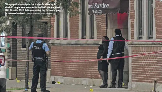  ?? TYLER PASCIAK LARIVIERE/SUN-TIMES (FILE) ?? Chicago police investigat­e the scene of a shooting in which 15 people were wounded in the 1000 block of West 79th Street in 2020. Police suspected the Faceworld gang faction was involved.