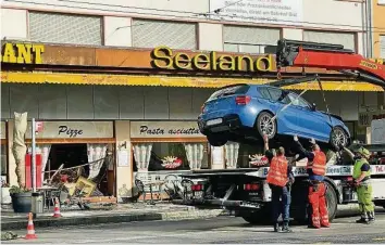  ?? LE MATIN ?? Das Auto der Lernfahrer­in wird geborgen. Es war direkt ins Fenster der Pizzeria gefahren. Video: 20 Minuten war nach dem Unfall auf dem gesperrten Bahnhofpla­tz vor Ort.