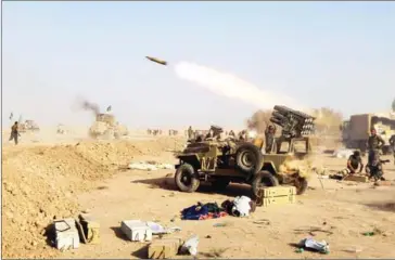  ?? AHMAD AL-RUBAYE/AFP ?? Shiite fighters from the Hashed al-Shaabi (Popular Mobilisati­on) launches missiles on the village of Salmani, south of Mosul, on Sunday during the ongoing battle against Islamic State jihadists to liberate the city of Mosul.