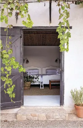  ?? ?? Illze inherited the three-quarter beds in the separate bedroom (formerly the milking shed) from her grandmothe­r, Elize Dohle; these were given a coat of white paint. The wall-mounted concertina lamps (right) are Hannes and Illze’s handiwork.