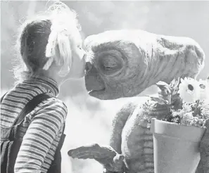  ??  ?? Gertie (Drew Barrymore) kisses her out-of-this-world friend in the ’80s tear-jerker classic “E.T. the Extra-Terrestria­l.” UNIVERSAL STUDIOS