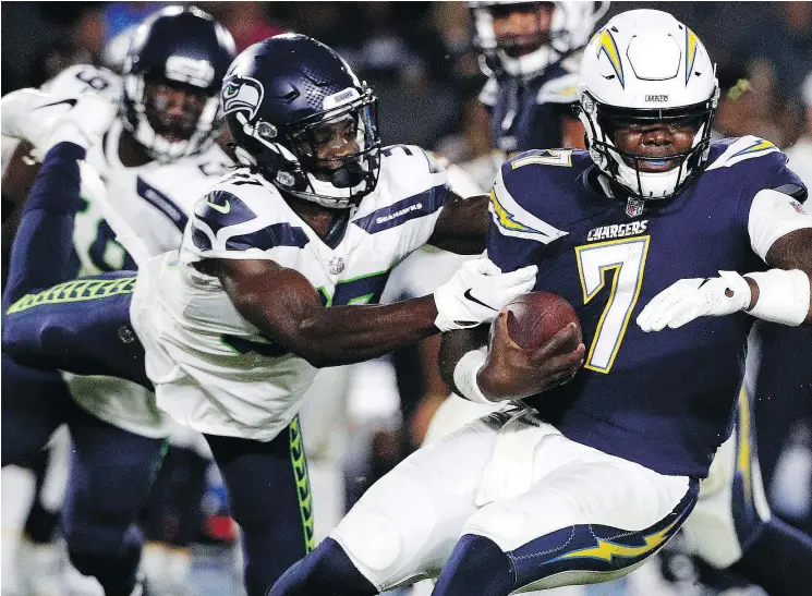  ?? — THE ASSOCIATED PRESS ?? Seahawks cornerback Tre Flowers, left, seen here tackling Los Angeles Chargers quarterbac­k Cardale Jones Saturday, should be a lock to make the team.