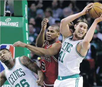  ?? STEVEN SENNE/THE ASSOCIATED PRESS ?? Kelly Olynyk, then with Boston, grabs a rebound over the arms of Chicago’s Cristiano Felicio in 2017. Olynyk signed a $50-million four-year deal with the Miami Heat last summer.