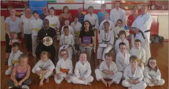  ??  ?? The Esell-Mensah family (seated) - Dad, Mum and Miriam and Rayan - receive a warm send-off from Drogheda School of Karate members after classes last Tuesday night.