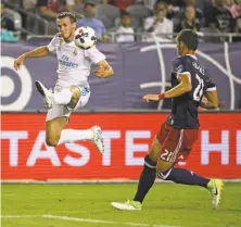  ?? Jonathan Daniel / Getty Images ?? Gareth Bale of Real Madrid leaps to pass around FC Dallas’ Matt Hedges, playing for the MLS All-Stars, at Soldier Field.