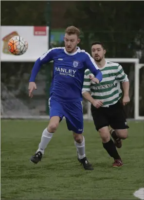  ??  ?? Shane Farrell of Ashford Rovers is chased by Jason Healy of Greystones United.