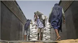  ?? (AFP) ?? Workers carry sacks of wheat to load on a freight train at Chawa Pail railway station in Khanna, Punjab state, on May 19