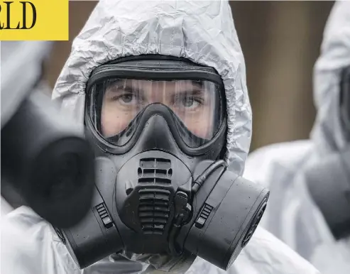  ?? CHRIS J. RATCLIFFE / GETTY IMAGES ?? Military personnel in protective suits continue to probe the poisoning of a former Russian spy in Salisbury, England. Sergei Skripal and his daughter remain in critical condition after being attacked with a nerve agent.