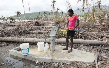  ?? — THE ASSOCIATED PRESS FILES ?? Gelene Jeudy, 16, pumps water from a contaminat­ed well in Aux Coteaux, a district of Les Cayes, Haiti. The federal government has announced another $54 million in aid to Haiti.