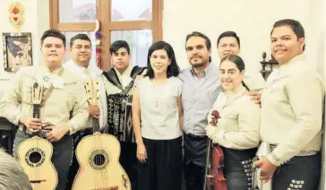  ??  ?? > El festejado y su esposa posan con el mariachi que amenizó el evento.