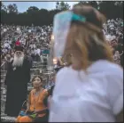  ??  ?? A steward wearing
plastic visor stands in front of a Greek Orthodox priest as spectators take their seats at the ancient theater of Epidaurus.