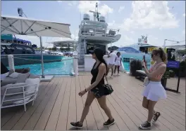  ?? DARRON CUMMINGS — THE ASSOCIATED PRESS ?? Race fans walk through the man-made marina and beach club before the Formula One Miami Grand Prix auto race at Miami Internatio­nal Autodrome on Friday.