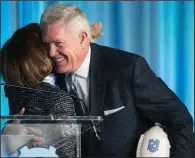  ?? AP/The News & Observer/ROBERT WILLETT ?? Mack Brown (right) hugs University of North Carolina Chancellor Carol Folt after being introduced as the school’s football coach Tuesday in Chapel Hill, N.C. Brown spent 10 seasons at North Carolina before leaving for Texas and later becoming a broadcaste­r.