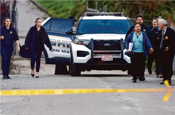  ?? Carlos Gonzalez/The Chronicle ?? San Mateo County sheriff ’s personnel and paramedics walk near where four people were found shot to death on Monday in Half Moon Bay.